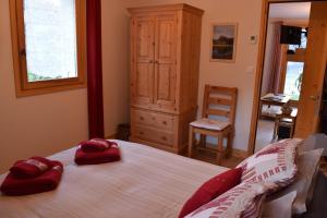 una camera da letto con un letto con due cuscini rossi sopra di Apartment La Tibolire a Sixt