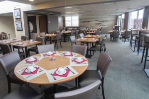 une salle à manger avec des tables et des chaises en bois dans l'établissement Mercure Vannes Le Port, à Vannes