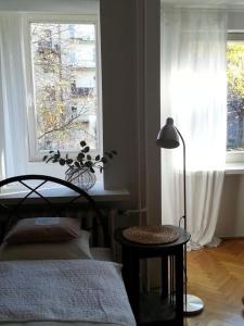 1 dormitorio con cama, ventana y lámpara en Pokój z widokiem, en Cracovia