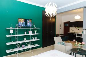 a living room with a green wall and white shelves at Cosy Downtown Studio - Suite in Komotini