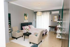 a bedroom with a bed and a chair and a table at Cosy Downtown Studio - Suite in Komotini