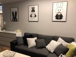 a living room with a couch and some pictures on the wall at Family & Business Elegant Apartments Rynek Centrum Downtown - 2 Bedroom, Balcony, Parking in Kielce
