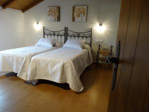 a bedroom with a large bed with white blankets and pillows at Alojamiento Rural El Lario in Alcalá de los Gazules +55 photos