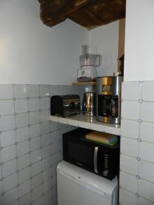 a kitchen with a microwave and a toaster oven at Domaine du Manoir de Vains in Vains