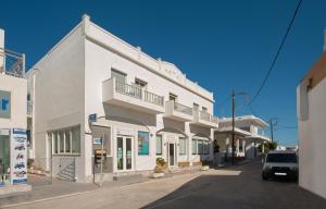 a white building on the side of a street at Hotel Meltemi in Adamantas