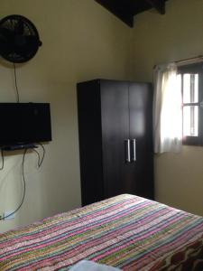 1 dormitorio con 1 cama y armario negro en Cabañas el Gauchito en Los Reartes