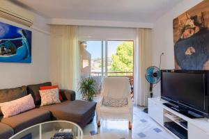 a living room with a couch and a flat screen tv at Apartamento con parking gratuito in Málaga