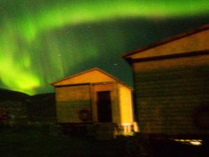 a house with the green northern lights in the sky at Teriberka Tour in Teriberka