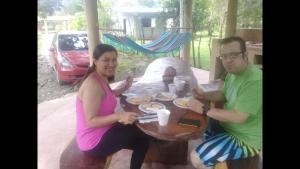 Ein Mann und eine Frau sitzen an einem Tisch in der Unterkunft Hostal Lopez El Valle Cabañas in El Valle de Antón