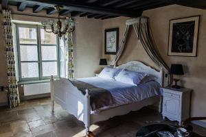 a bedroom with a white bed with a canopy at Manoir Sainte Victoire in Bayeux