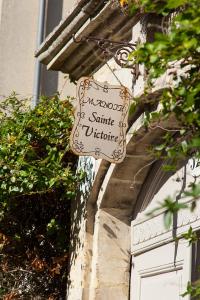 una señal en el lateral de un edificio al lado de una puerta en Manoir Sainte Victoire en Bayeux