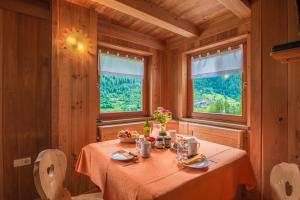 a dining room with a table and two windows at Mas De La Bolp - Chalet in Rabbi