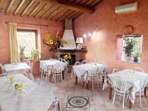 comedor con mesas y sillas y chimenea en Agriturismo Da Paola, en Marsiliana