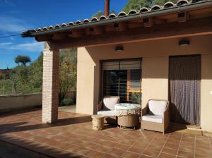 un patio con 2 sillas y una mesa en Puerta de Sobrarbe - Torreciudad en El Grado