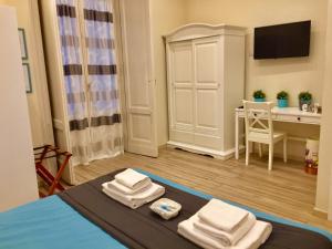 a room with a bed and a table with towels on it at Da Polly a Piazza Amedeo in Naples