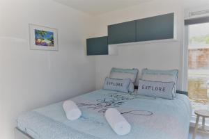 Dormitorio blanco con cama con colcha azul y almohadas blancas en Boatlodge, Anegada en Maastricht