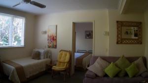 a living room with a couch and a bed at Alfa Boutique Motel in Paihia