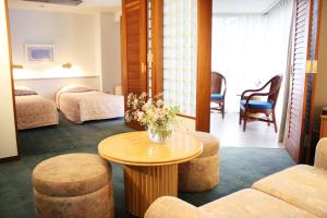 a hotel room with a table and two beds at Fuji Premium Resort in Fujikawaguchiko