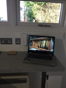 a laptop computer sitting on a desk next to a window at Portree Garden Room in Portree