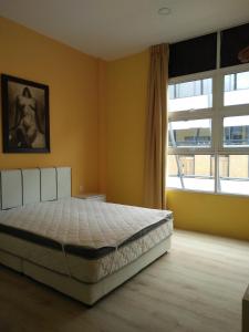 a bedroom with a bed and a large window at Xenia Homestay in Kuching