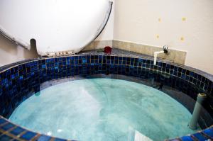 a bath tub with a toilet sitting on top of it at Midway Motel Rotorua in Rotorua