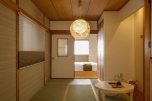 a hallway with a door and a table and a bed at Bijou Suites Will in Osaka