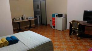 1 dormitorio con cama, escritorio y ordenador en Studio in Samara. A/C. H/W. 35m2. 200mts to the beach., en Sámara