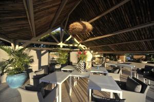 a restaurant with tables and chairs and a ceiling at THE BAHI VILLA - Adults Only B&B in Les Trois-Îlets