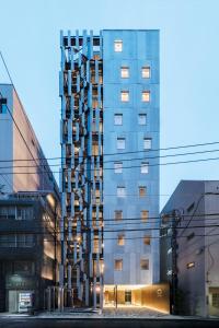 wysoki budynek z wieloma oknami w mieście w obiekcie Hotel Comfact w Tokio