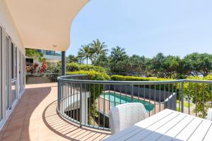 a balcony with a view of a swimming pool at Location, location, Sunshine Beach in Sunshine Beach