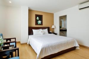 ein Schlafzimmer mit einem großen weißen Bett in einem Zimmer in der Unterkunft ALUNA Ben Thanh Hotel in Ho-Chi-Minh-Stadt