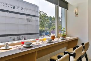 a dining room with a table and chairs and a window at ALUNA Ben Thanh Hotel in Ho Chi Minh City