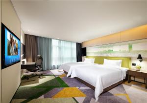 Кровать или кровати в номере Hampton by Hilton Guangzhou Tianhe Sports Center-Free Shuttle Bus to Exhibition During Canton Fair Period