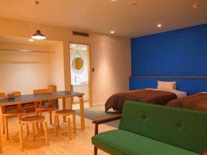 1 dormitorio con 1 cama, mesa y sillas en Saihokuso inn en Ueda