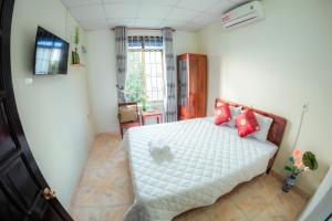 a bedroom with a white bed with red pillows at Rubis Hostel in Hue +14 photos