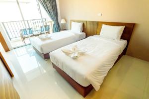 um quarto de hotel com duas camas e uma janela em G Residence em South Pattaya