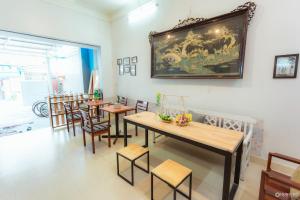 a restaurant with tables and chairs and a painting on the wall at Rubis Hostel in Hue