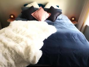 a bed with a white blanket and pillows on it at Central Rotorua Beauty in Rotorua