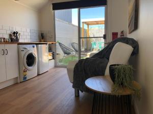 a living room with a chair and a washing machine at Tiny Tom - Hidden beside the river Mersey in Devonport
