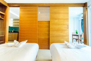 two beds in a room with wooden walls at G Residence in Pattaya South