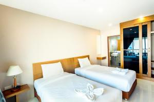 1 dormitorio con 2 camas con sábanas blancas con arcos en G Residence en Pattaya South