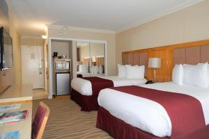 a hotel room with two beds and a kitchen at Ocean Sky Hotel & Resort in Fort Lauderdale +37 photos