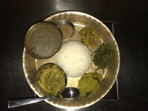 a plate of food with rice and vegetables on a table at Rupa View Guest house in Pokhara