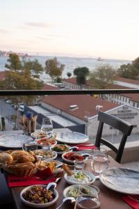 einen Tisch mit Tellern aus Essen auf einem Balkon in der Unterkunft Meydan Besiktas Hotel in Istanbul