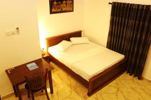 a small bedroom with a bed and a table at Ashford Beach in Matara