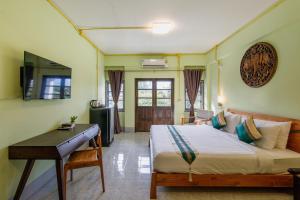 ein Schlafzimmer mit einem Bett und einem Schreibtisch. in der Unterkunft Double Lucky House in Chiang Mai