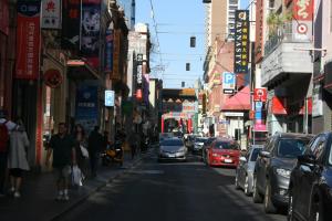 uma rua movimentada da cidade com carros e pessoas andando pela rua em Arden Motel em Melbourne
