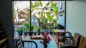 ein Restaurant mit einem Tisch, Stühlen und Pflanzen in der Unterkunft Sangchan hostel in Ko Lipe