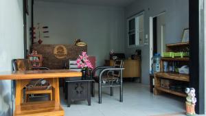 ein Wohnzimmer mit Stühlen und einem Tisch mit Blumen in der Unterkunft Sangchan hostel in Ko Lipe