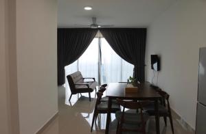 een eetkamer met een tafel en stoelen en een raam bij 2-Bedroom Apartment@Trefoil Setia Alam in Shah Alam